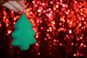 beautiful green Christmas tree is lying on your hand on a shiny background