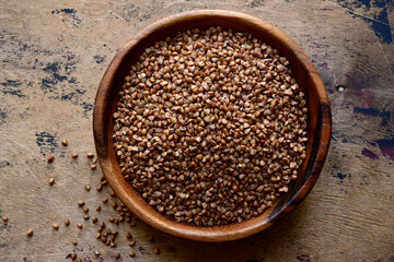 Raw organic buckwheat in a wooden bowl. Top view with copy space.