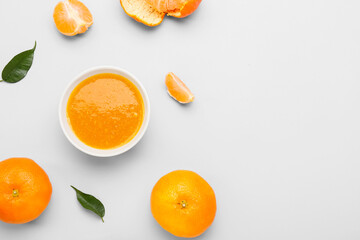 Fototapeta na wymiar Bowl of tasty tangerine jam on white background