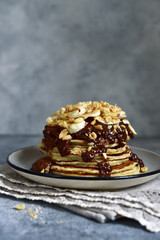 Banana pancakes with chocolate sauce and nuts.
