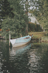 Old blue boat at the pier on the river in the village