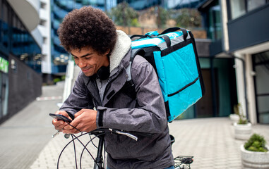 Obraz premium Male courier with bicycle delivering packages in city.