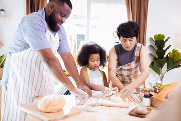 Happy African American family enjoy together while prepare the flour for making cookies at home