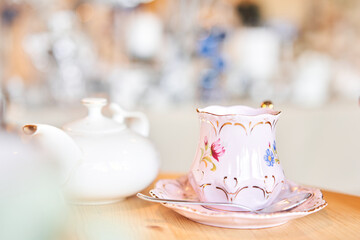 teapot and cup. A magnificent porcelain tea set with a fragrant tea. Green and black tea concept. Side view.