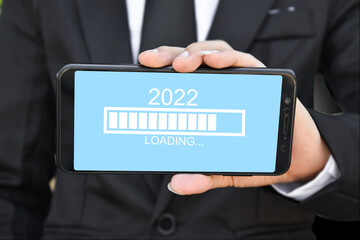 Loading new year 2022. Businessman holding mobile phone with progress bar.