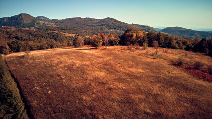 Aerial drone view of countryside hilly landscape in autumn colors.