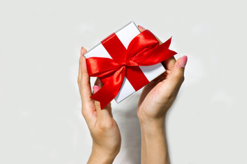 Woman's hands holding Christmas gift box on white background. Christmas and Holiday background concept