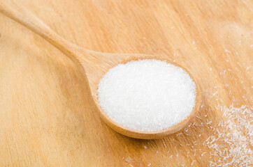 Monosodium glutamate in wooden spoon.