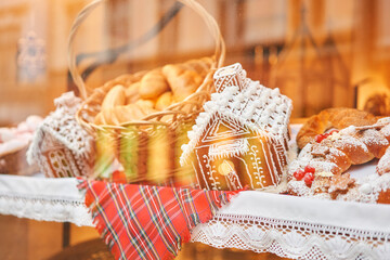 A bakery showcase in a European city for Christmas. Gingerbread house, pretzel, apple crumble, buns. Bread on Christmas and New year