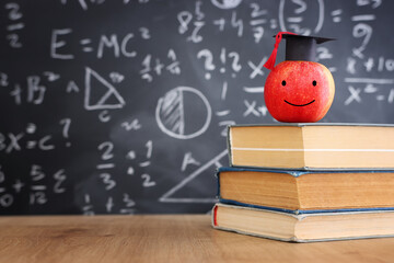 School books on desk infront of blackboard with formulas. education concept