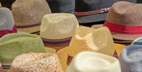 Many hats for men in different shapes and colors in one display for sale