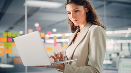 Young Confident Businesswoman Using Laptop Computer in Modern Office with Colleagues. Stylish Beautiful Manager Working on Commercial, Financial and Marketing Projects. Specialist in Diverse Team.