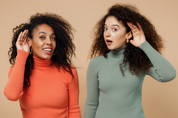 Two curious nosy charming vivid young curly black women friends 20s wearing casual shirts clothes...