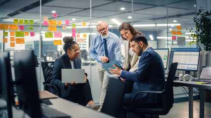 In Modern Office: Diverse Team of Managers Use Laptop and Tablet Computers at a Company Meeting...