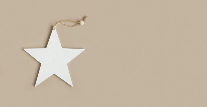 Eco christmas toys. Wooden christmas star decoration on neutral beige background with copy space. Eco friendly Christmas decor for home, zero waste concept. Composition in eco-style. Top view