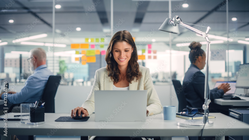 Poster young happy businesswoman using computer in modern office with colleagues. stylish beautiful manager