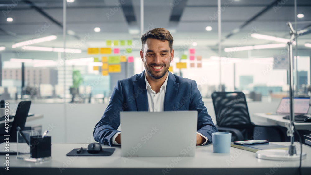 Poster Busy Young Businessman Using Laptop Computer in Modern Office. Manager Thinks About Successful Financial Ideas. Happy Man Smiling About Finding Problem Solving Solutions for Company.