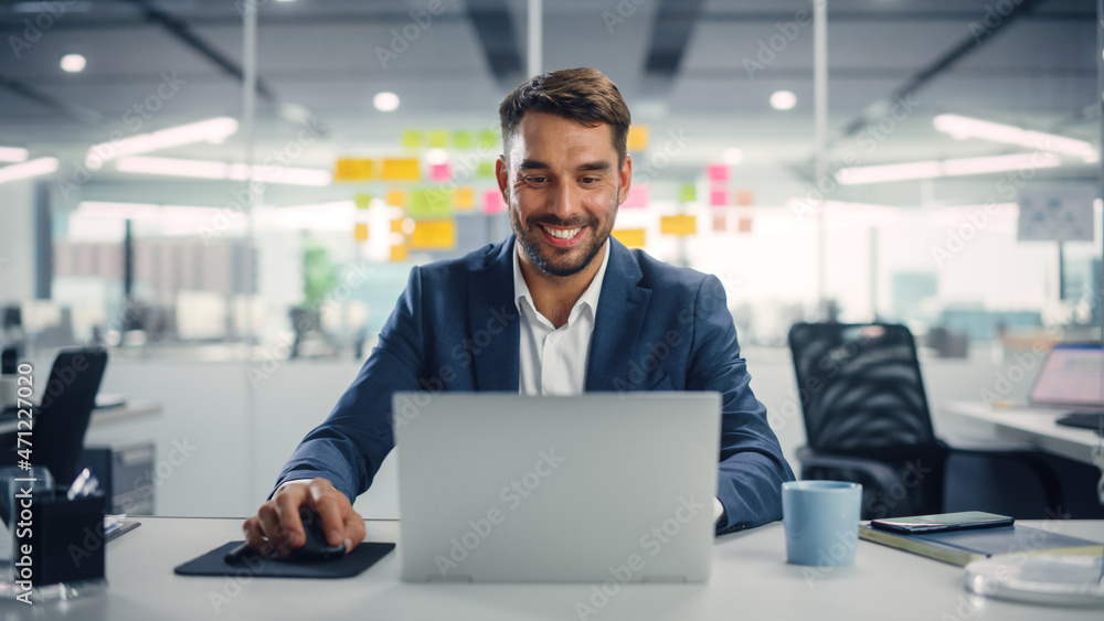 Poster young happy businessman using computer in modern office with colleagues. successful handsome manager