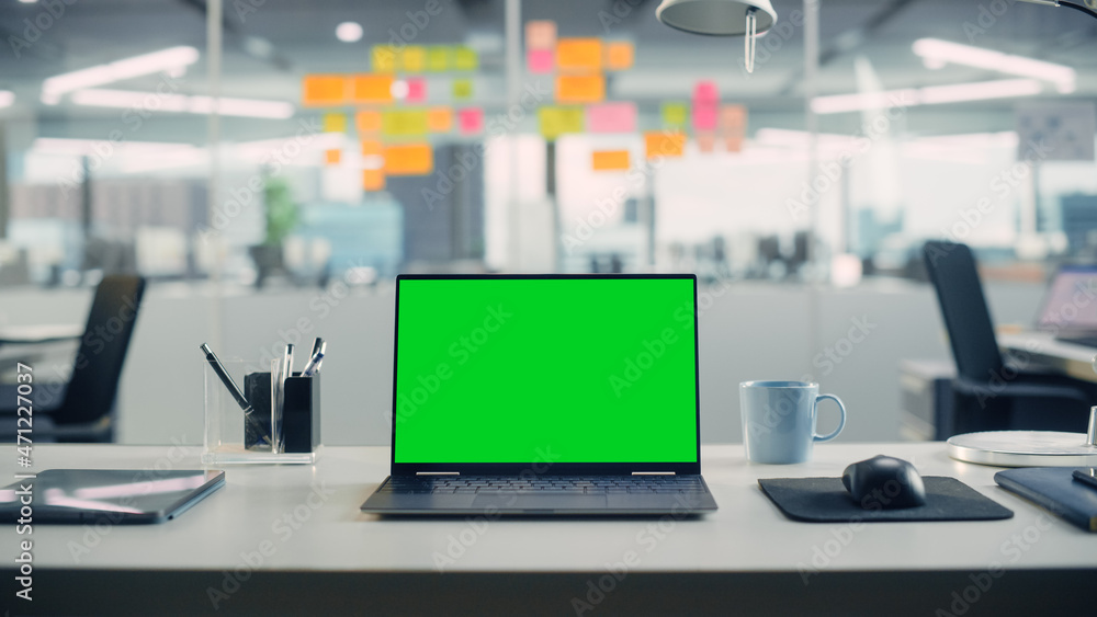 Leinwandbilder Laptop Computer with Mock Up Green Screen Chroma Key Display Standing on the Desk in the Modern Creative Office. In the Background Glass Wall with Colorful Planning Notes.