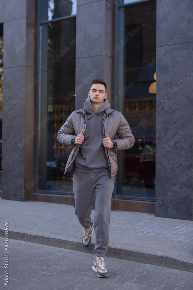 Wall mural Man walking in city wearing winter jacket