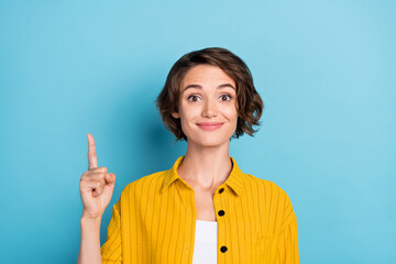 Photo of excited lady direct forefinger up empty space novelty wear yellow shirt isolated blue...