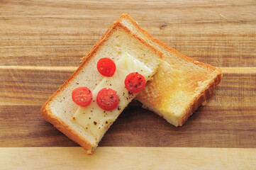 食パンをトーストしてバターを塗りチーズとトマトを乗せる