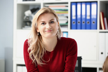 Fototapeta premium Beautiful young woman office worker posing in personal cabinet