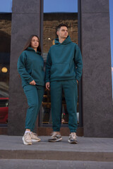 Obraz na płótnie Canvas Couple posing in city wearing green hoodie