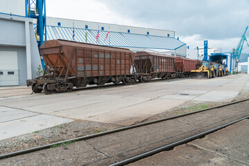 Obraz premium Freight trains, tractors with buckets at the terminal in the port