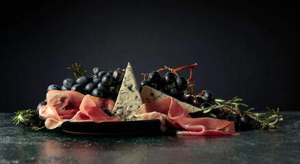 Prosciutto with blue cheese, grapes, and rosemary.