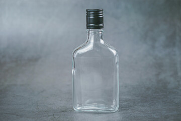 A 200ml glass bottle with black cap isolated on grey background 