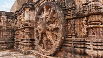 Richly carved Chariot wheel with eight spokes with a central medallion. Deities and erotic and amorous figures shown. Konark Sun Temple, Orissa India