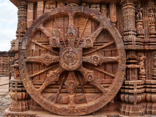 Richly carved Chariot wheel with eight spokes with a central medallion. Deities and erotic and amorous figures shown. Konark Sun Temple, Orissa India
