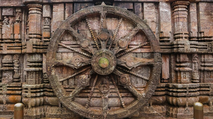 Richly carved Chariot wheel with eight spokes with a central medallion. Deities and erotic and amorous figures shown. Konark Sun Temple, Orissa India