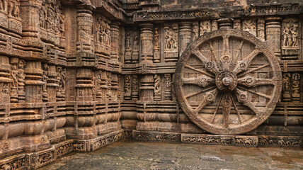Richly carved Chariot wheel with eight spokes with a central medallion. Deities and erotic and...