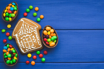 Gingerbread and colored sweets on a blue  wooden background.  Place for text or logo.