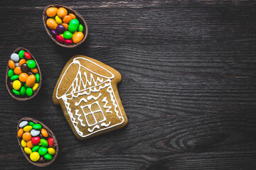 Gingerbread and colored sweets on a wooden background.  Place for text or logo.
