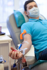 bone marrow donation. male hand holding red ball, blood transfusion system, blood bag.  vertical,...