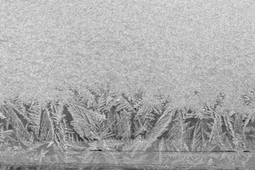 Frost on the window, Natural texture on glass with frozen pattern. Copy space, natural background, macro. Beautiful winter background