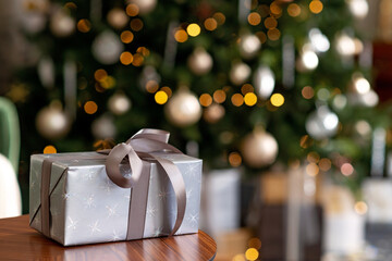 Christmas and New Year background - gift boxes, presents, against the background of bokeh lights of a decorated Christmas tree. Soft selective focus.