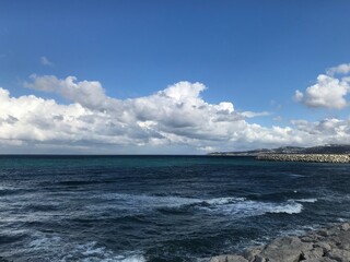 Scenic white clouds of type cumulus over dark blue colored ocean sea
