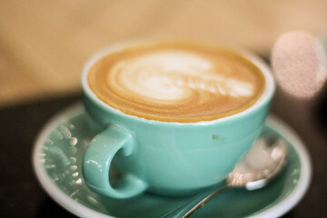 cup of coffee with latte art green cup close up