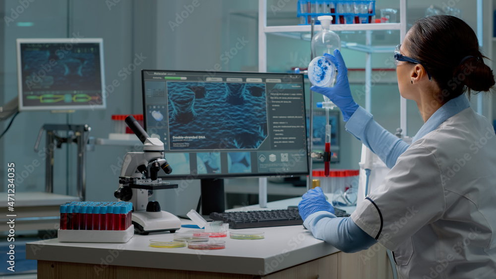 Aufkleber innovation scientist studying petri dish with liquid bacteria while using modern computer with cell 