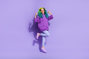Full length photo of cheerful wavy curly haired lady jump up show thumbup symbol suggest ads isolated over purple color background