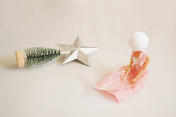 Christmas tree on a grey background. New year's expectations. Depressed girl is sitting next to a fallen Chrismas tree.