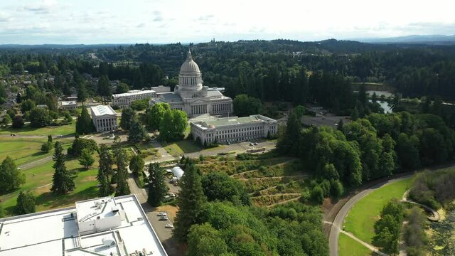 Cinematic 4K aerial drone dolly out shot of the Washington State Capitol Building and Campus, Capitol Lake, with a panoramic view of Historic District in Olympia, Washington