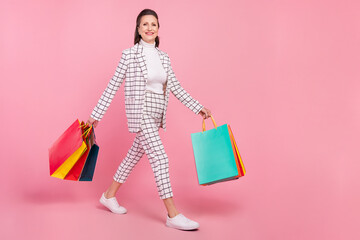 Full size photo of cheerful beautiful grandmother go shopping crazy shopaholic isolated on pink color background