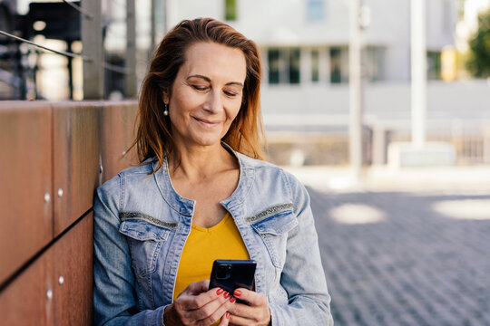 Natural portrait of a woman smiling as she reads a phone message