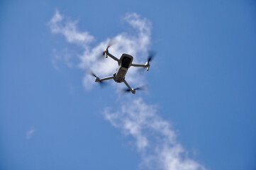 White Drone Flying on Nature Background. Drone Hanging in Air Flying Helicopter Dron Remote Control Air Drone