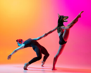 Two dancers, flexible couple headed of dog's heads dancing contemporary dance on colorful gradient yellow pink background in neon light.
